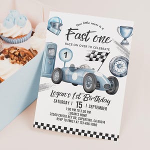 May include: A blue and white race car themed birthday invitation with a checkered flag, a gas pump, and a race car. The invitation says "Our little racer is a Fast One" and includes the text "Logan's 1st Birthday, Saturday | 15 | September, 1:00 PM to 3:00 PM, Logan's Home, 22500 Cristo Rey Dr, Cupertino, CA 95014, RSVP to Emily at 123-456-7890".