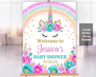 May include: A pink and blue unicorn baby shower welcome sign with a rainbow background and gold glitter accents. The sign says "Welcome to Jessica's Baby Shower 07.20.25".