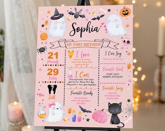 May include: A pink birthday milestone sign featuring Halloween-themed illustrations of ghosts, a black cat, a pumpkin, and bats. The text includes the name Sophia, My First Birthday, and sections for weight of 21 pounds, height of 29 inches, and 7 teeth.