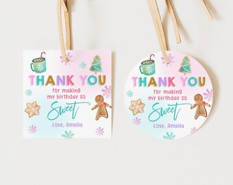 May include: Two thank you tags with a winter theme. The tags are pink and blue with snowflakes and gingerbread cookies. The text on the tags reads "Thank you for making my birthday so sweet. Love, Amelia."