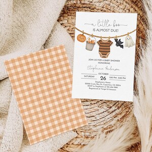 May include: A baby shower invitation with a Halloween theme. The invitation features a pumpkin, a bucket of candy, a onesie, a bat, and a ghost hanging on a clothesline. The text reads "a little boo is almost due!" and includes event details.