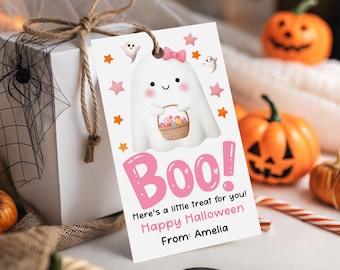 Puede incluir: Una etiqueta de regalo blanca de Halloween con un fantasma de dibujos animados sosteniendo una cesta de golosinas. La etiqueta tiene estrellas rosas y la palabra "Boo!" en rosa. El texto dice "Here's a little treat for you! Happy Halloween From: Amelia."