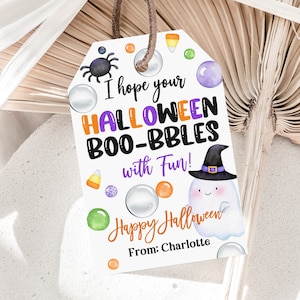 May include: A white tag with a purple, orange, and green Halloween theme. It says "I hope your HALLOWEEN BOO-BBLES with Fun!" and "Happy Halloween" with a cute ghost illustration. The tag is signed "From: Charlotte".