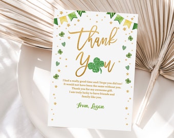 May include: A white St. Patrick's Day thank you card with gold lettering and green accents. The card features the words "Thank You" in a script font, a glittery green shamrock, and a message from Logan.