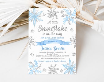 Op de afbeelding: Een uitnodiging voor een babyshower met een blauw en zilveren sneeuwvlokkenontwerp. De uitnodiging luidt "Een klein sneeuwvlokje is onderweg" en bevat de naam Jessica Brown, de datum en tijd van de babyshower en het adres.