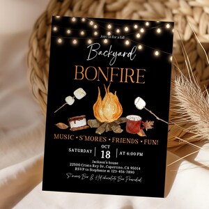 May include: Black invitation card with the words "Backyard Bonfire" in a decorative font. The card features illustrations of a bonfire, marshmallows, and a mug of hot chocolate. The date and time of the event are also included.