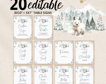 May include: A set of 20 editable table signs in 8x10 and 5x7 inch sizes, featuring a winter theme with a white polar bear, snowy mountains, pine trees, and snowflakes. The signs include text for various events like Diaper Raffle and Hot Chocolate Bar.