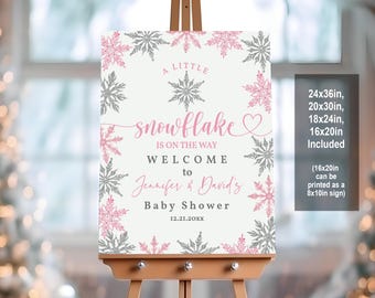 May include: A pink and gray baby shower welcome sign with snowflakes and the text "A Little Snowflake is on the Way. Welcome to Jennifer & David's Baby Shower 12.21.20XX".
