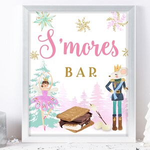 Puede incluir: Un cartel imprimible para una barra de s'mores con un fondo rosa y una ilustración caprichosa de una bailarina y un cascanueces. El cartel dice "S'mores Bar" en texto rosa.