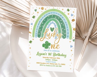 May include: A St. Patrick's Day themed invitation with a watercolor rainbow in shades of green and blue, gold glitter text that reads "Lucky One", and a green shamrock. The invitation includes event details for Logan's 1st Birthday.