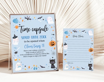 May include: A blue and white time capsule sign with a ghost, pumpkin, and bats. The sign says "Time Capsule Sealed Until 20XX to be opened when Oliver turns 18". A matching blue and white card says "Dear Oliver" with lines for writing.