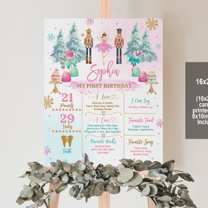 May include: A pink and blue first birthday sign with a watercolor background featuring a nutcracker and a ballerina. The sign includes the child's name, Sophia, and details about their first year, including their weight, height, and favorite things. The sign is 16x20 inches and can be printed as an 8x10 inch sign.