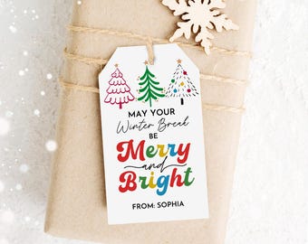 May include: A gift tag with three Christmas trees in red, green, and white, tied to a wrapped package. The tag reads "May Your Winter Break Be Merry and Bright" with the name "Sophia" at the bottom. The package is wrapped in brown paper and tied with twine.
