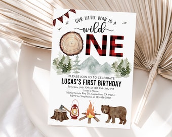 May include: A woodland-themed first birthday invitation with a red and black plaid "ONE" and a cartoon bear. The text reads "Our little bear is a wild one. Please join us to celebrate Lucas's first birthday. Saturday, July 30th at 1:00 PM - 3:00 PM. Lucas's Home. 22500 Cristo Rey Dr, Cupertino, CA 95014. RSVP to Stephanie at 123-456-7890."
