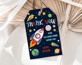May include: A blue thank you tag with a rocket ship, stars, planets, and the text "THANK YOU! FOR CELEBRATING WITH ME! LOVE, JACOB".