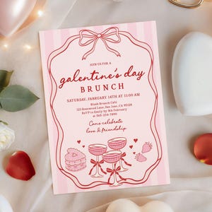 May include: Pink Galentine's Day brunch invitation with a bow-shaped frame and vertical stripes. The invitation includes text about the event, featuring illustrations of champagne glasses, a cake, and strawberries. The invitation is surrounded by decorative elements.