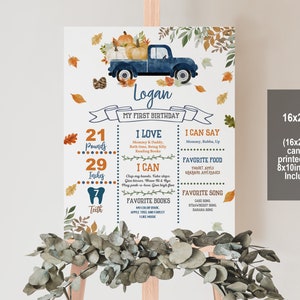 Puede incluir: Un camión azul con calabazas y hojas de otoño en la parte trasera. El camión está sobre un fondo blanco con un borde azul y naranja. El texto "Logan" está en la parte superior del póster. El póster también incluye información sobre el primer cumpleaños de Logan, incluyendo su peso, altura, comidas favoritas y canciones. El póster mide 16x20 pulgadas y se puede imprimir como un cartel de 8x10 pulgadas.