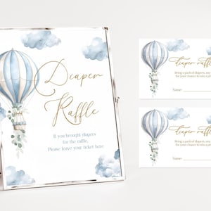 May include: A framed sign and two raffle tickets with a watercolor hot air balloon design. The sign reads "Diaper Raffle" with additional text. The tickets also feature the hot air balloon and text for a diaper raffle.