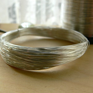 May include: A close-up of a silver wire coil, likely used for jewelry making or crafting.