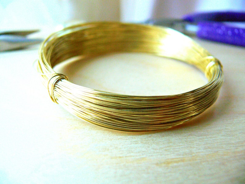 May include: A spool of gold-colored wire, wound tightly in a coil.