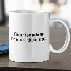 May include: White ceramic coffee mug with black text that reads "You can't say no to me. I'm on anti-rejection meds."