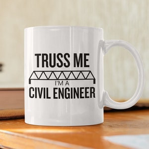 Op de afbeelding: Witte keramische mok met een zwarte afbeelding waarop staat "TRUSS ME I'M A CIVIL ENGINEER" met een zwart vakwerkbrugontwerp.