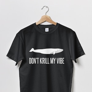 以下が含まれることがあります： 白いクジラのグラフィックと「Don't Krill My Vibe」というテキストが書かれた黒いTシャツ。