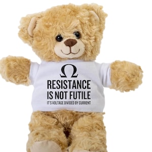 Puede incluir: Un oso de peluche marrón que lleva una camiseta blanca con el texto "Ω RESISTANCE IS NOT FUTILE IT'S VOLTAGE DIVIDED BY CURRENT"