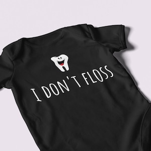 Peut inclure: Combinaison noire pour b&eacute;b&eacute; avec une dent de dessin anim&eacute; blanche et le texte "Je ne passe pas de fil dentaire".