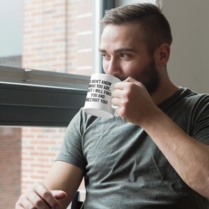 May include: White ceramic mug with the text "I DON'T KNOW WHO YOU ARE, BUT I WILL FIND YOU AND RECRUIT YOU!" in black. The mug is held by a person wearing a gray t-shirt.