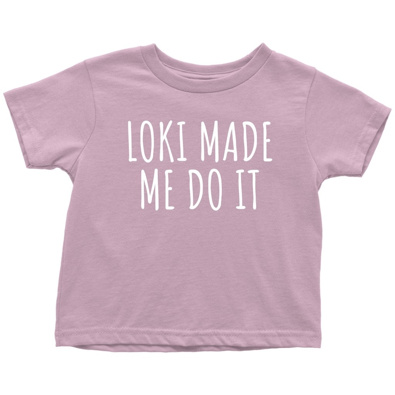 Op de afbeelding: Een lichtpaarse t-shirt met korte mouwen met de tekst "Loki Made Me Do It" in wit.