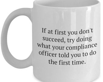 May include: White ceramic coffee mug with a black text quote: "If at first you don't succeed, try doing what your compliance officer told you to do the first time."