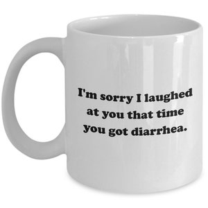 May include: White ceramic mug with a curved handle. The mug features black text that reads, "I'm sorry I laughed at you that time you got diarrhea."