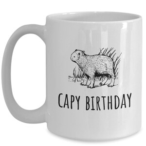 May include: White ceramic coffee mug with a black line drawing of a capybara and the text "CAPY BIRTHDAY".