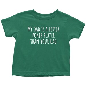 May include: A green t-shirt with the text "My Dad is a Better Poker Player Than Your Dad" in white.
