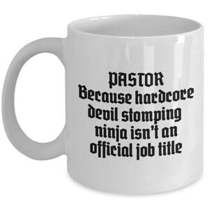 May include: White ceramic mug with a curved handle. The mug features black text that reads "PASTOR Because hardcore devil stomping ninja isn't an official job title."