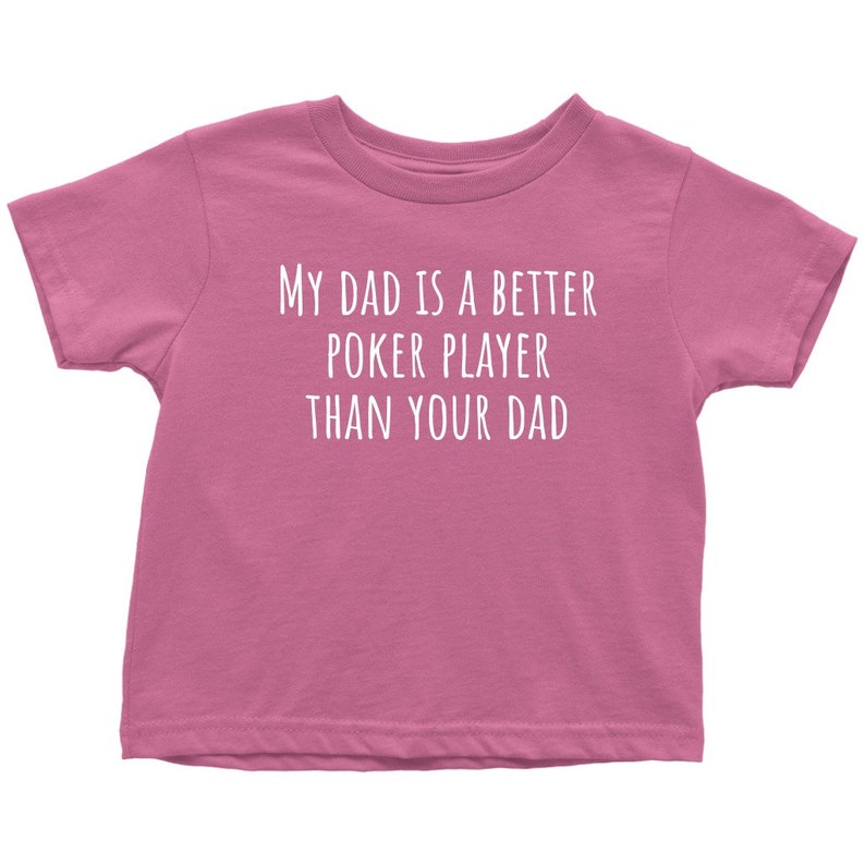 May include: Pink toddler t-shirt with white text that reads "My dad is a better poker player than your dad."