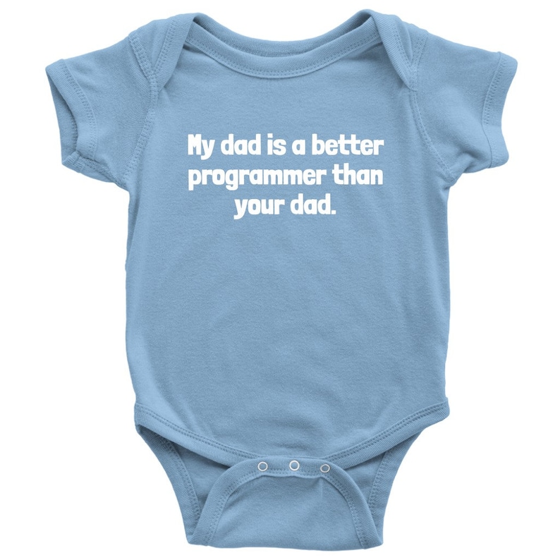 以下が含まれることがあります： 水色のベビーボディスーツ。白い文字で「My dad is a better programmer than your dad.」と書かれています。半袖で、下部にスナップが付いています。ユーモラスなベビー服です。