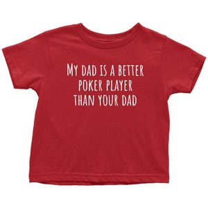 May include: Red toddler t-shirt with white text that reads "My dad is a better poker player than your dad."
