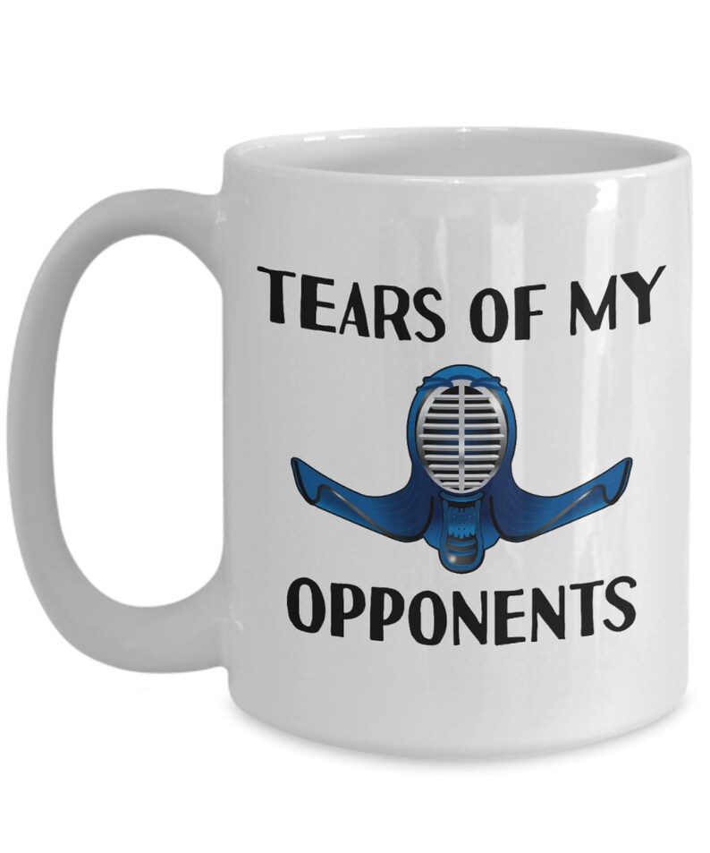May include: White ceramic coffee mug with a black and blue illustration of a kendo helmet and the text "Tears of my opponents".