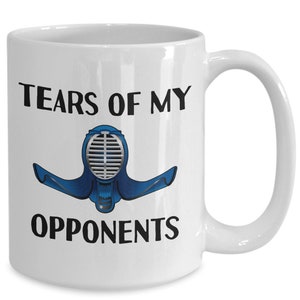 May include: White ceramic coffee mug with black text that reads "Tears of my opponents" and a blue and silver illustration of a kendo helmet.
