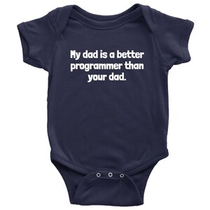以下が含まれることがあります： 紺色のベビーボディスーツ。白い文字で「My dad is a better programmer than your dad」と書かれています。半袖で、下部にスナップボタンが3つ付いています。