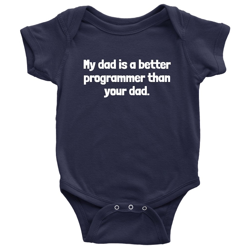 以下が含まれることがあります： 紺色のベビーボディスーツ。白い文字で「My dad is a better programmer than your dad」と書かれています。半袖で、下部にスナップボタンが3つ付いています。