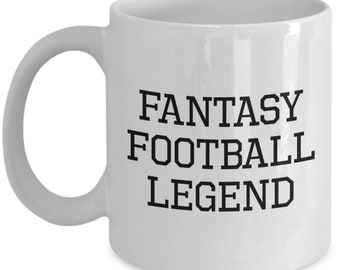 May include: A white ceramic mug featuring the black text FANTASY FOOTBALL LEGEND printed in a bold, block-style font on the front. The mug has a smooth, glossy finish, a cylindrical body, and a curved handle on the right side for easy gripping.