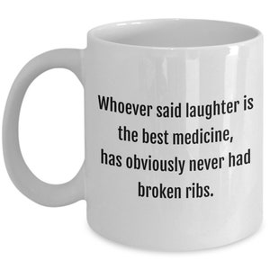 May include: White ceramic coffee mug with a black text quote that reads: "Whoever said laughter is the best medicine, has obviously never had broken ribs."