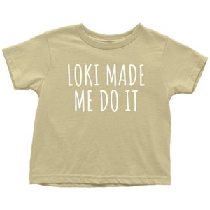 Op de afbeelding: Een lichtbeige T-shirt met korte mouwen met de tekst "Loki Made Me Do It" in wit.