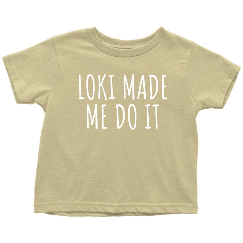 Op de afbeelding: Een lichtbeige T-shirt met korte mouwen met de tekst "Loki Made Me Do It" in wit.