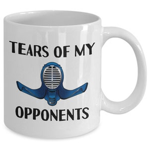 May include: White ceramic coffee mug with the text "Tears of my opponents" and a blue and silver kendo mask illustration.