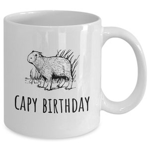 May include: White ceramic coffee mug with a black line drawing of a capybara and the text "CAPY BIRTHDAY".