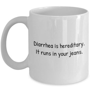 May include: White ceramic mug with a curved handle. The mug features the text "Diarrhea is hereditary. It runs in your jeans" in black, centered on the front. A humorous gift idea.